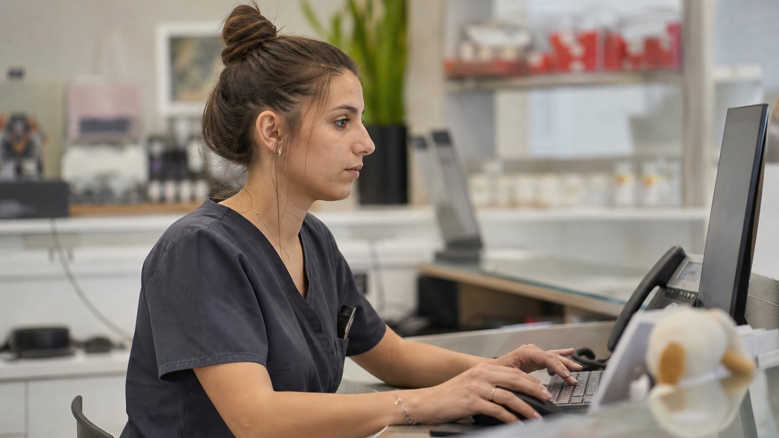 Assistante vétérinaire mettant à jour le numéro de téléphone d'un propriétaire sur la fiche de son animal