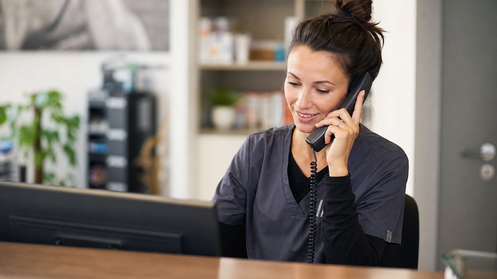 Assistante vétérinaire relançant par téléphone un propriétaire sans réponse à un rappel